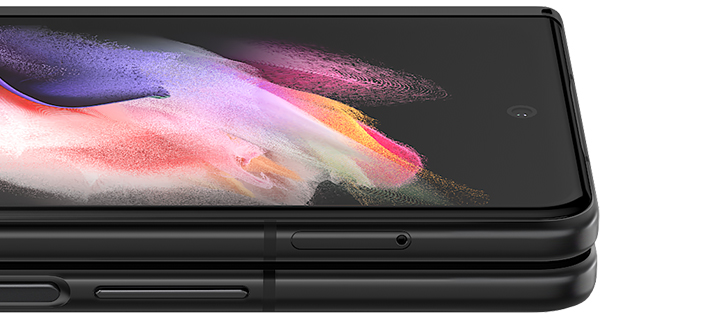 Folded Galaxy Z Fold3 5G seen from the open side. A colorful wallpaper is seen on the Cover Screen, and it turns slightly until only the edges show, to demonstrate how thin Corning® Gorilla® Glass Victus™ is.